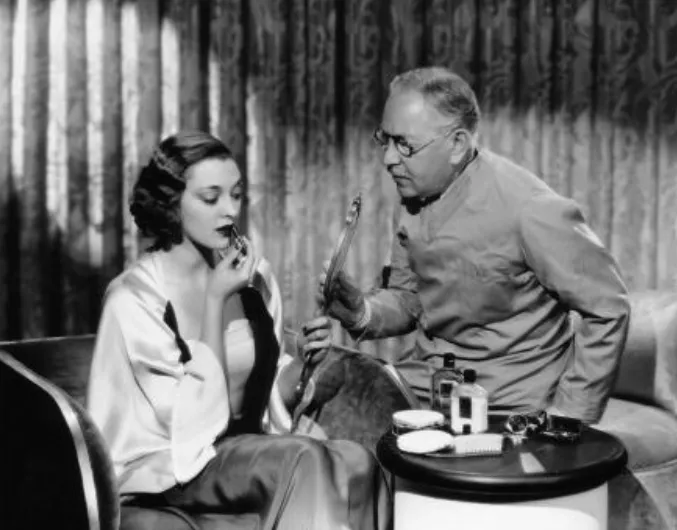 Maksymilian-Faktorowicz-Max-Factor-demonstruje-technike-nakladania-szminki-aktorce-Kathleen-Burke-1930