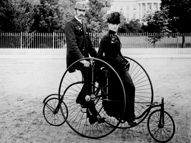 Elegancko-ubrana-para-siedzi-na-czterokolowcu-dla-dwojga-model-z-1886-roku.-–-jeden-z-ostatnich-„niepraktycznych-modeli-roweru-przed-rewolucja-technologiczna-w-branzy